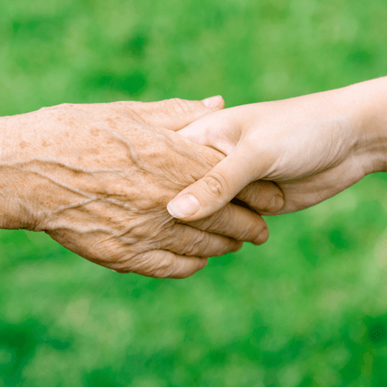 Elderly holding the hand of a youngster